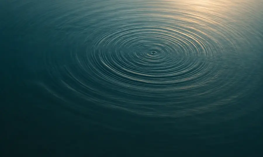 Ondes concentriques à la surface d’une eau calme aux reflets dorés